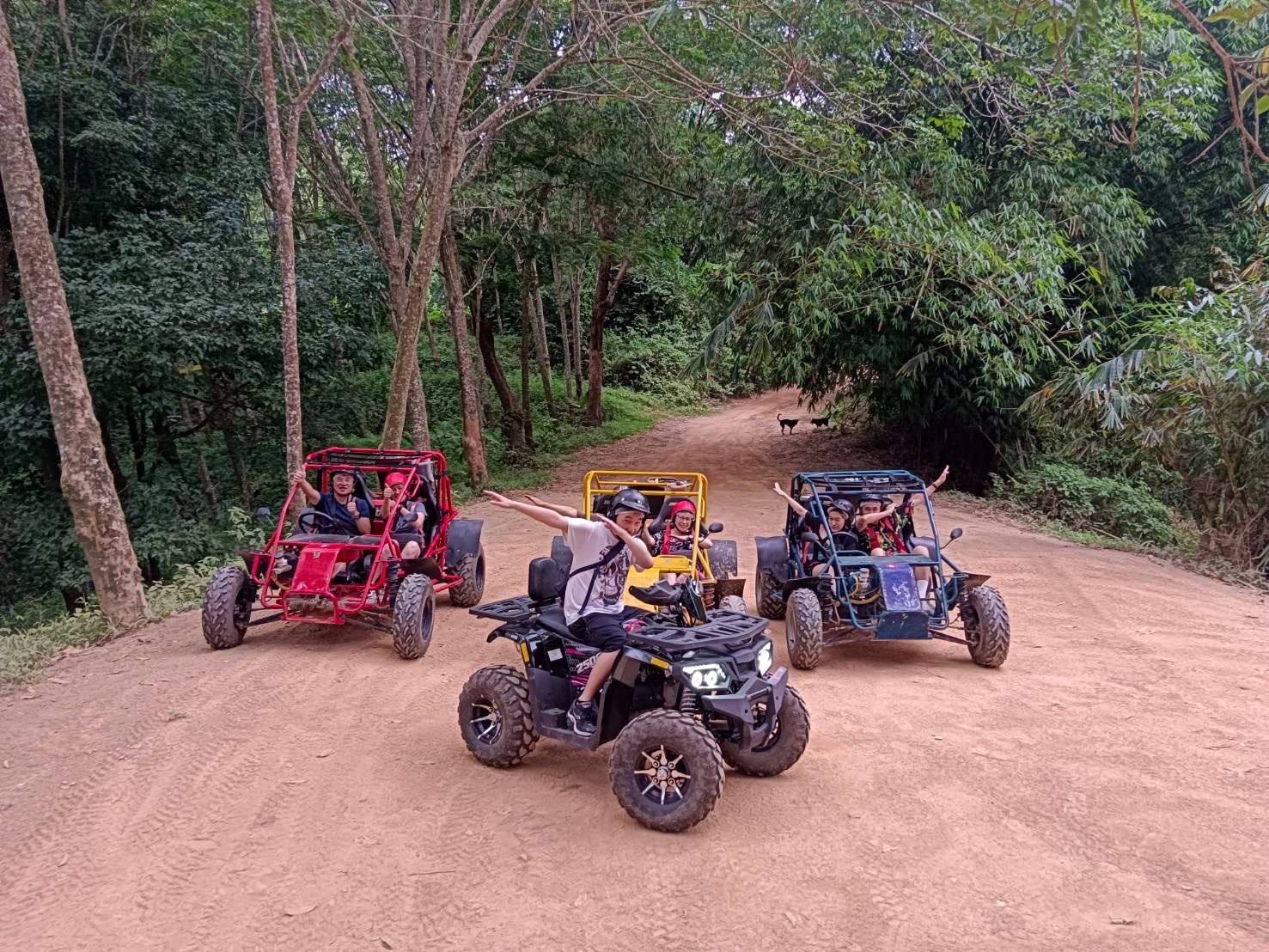 Mixed group of buggies and ATVs on a red-dirt trail