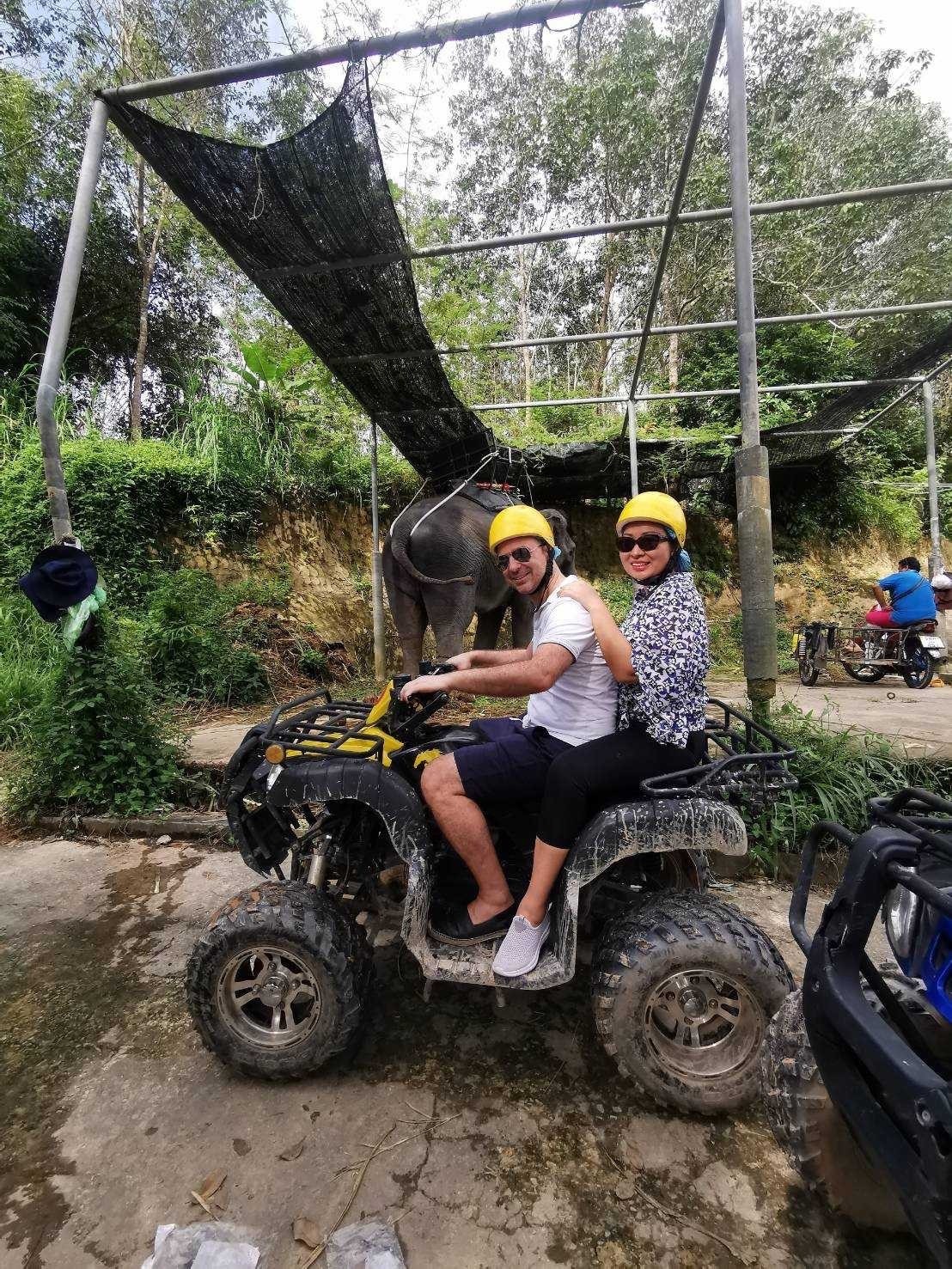 Couple on ATV with an elephant in the background
