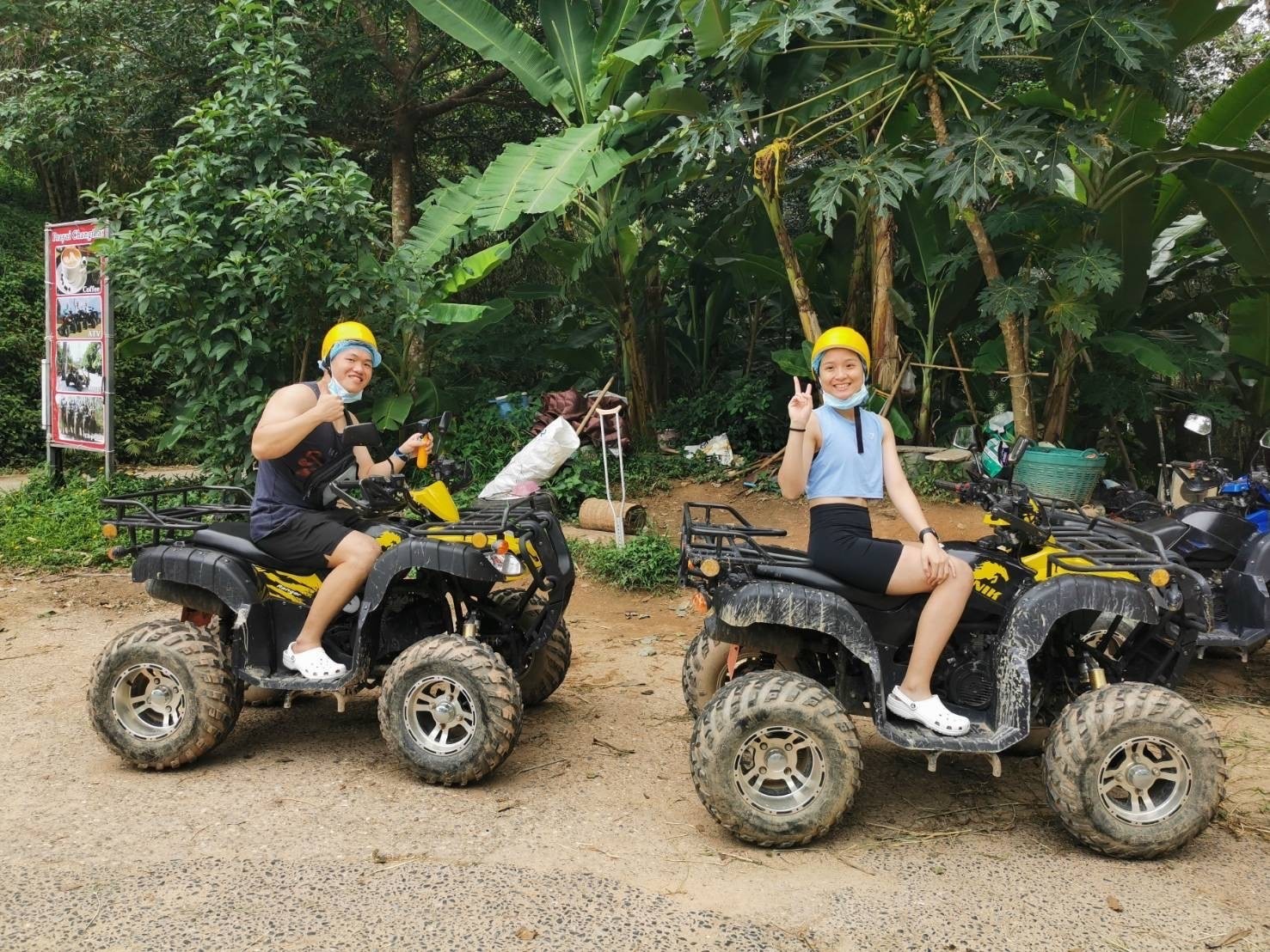 Couple in yellow helmets on ATVs in the Phuket jungle
