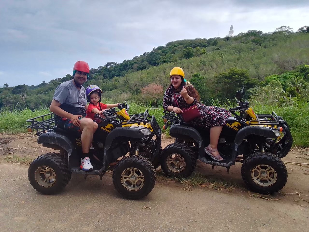 Family on ATVs with Phuket Big Buddha in the background