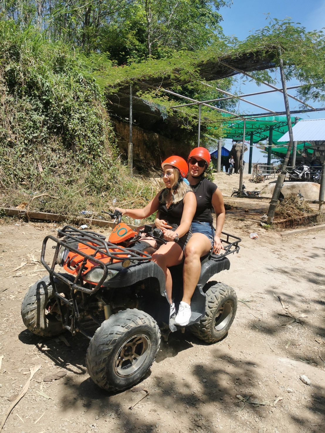 Two riders on a 250cc ATV in the jungle