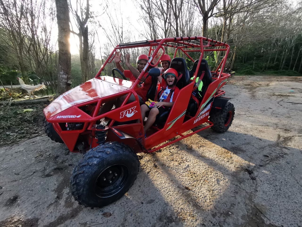 Family in a red 4-seat buggy on a jungle trail