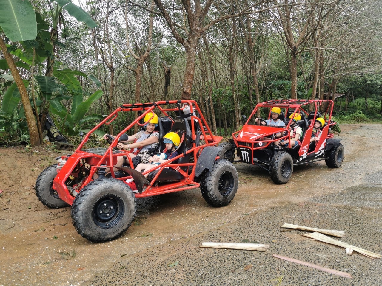 Two red buggies with families on a trail