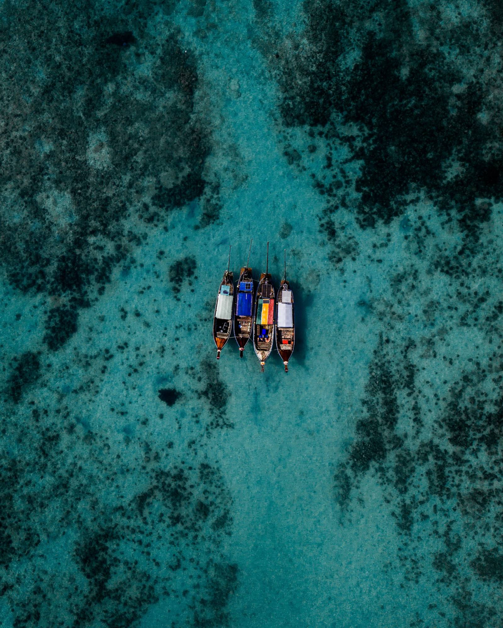Four longtail boats moored over the reef